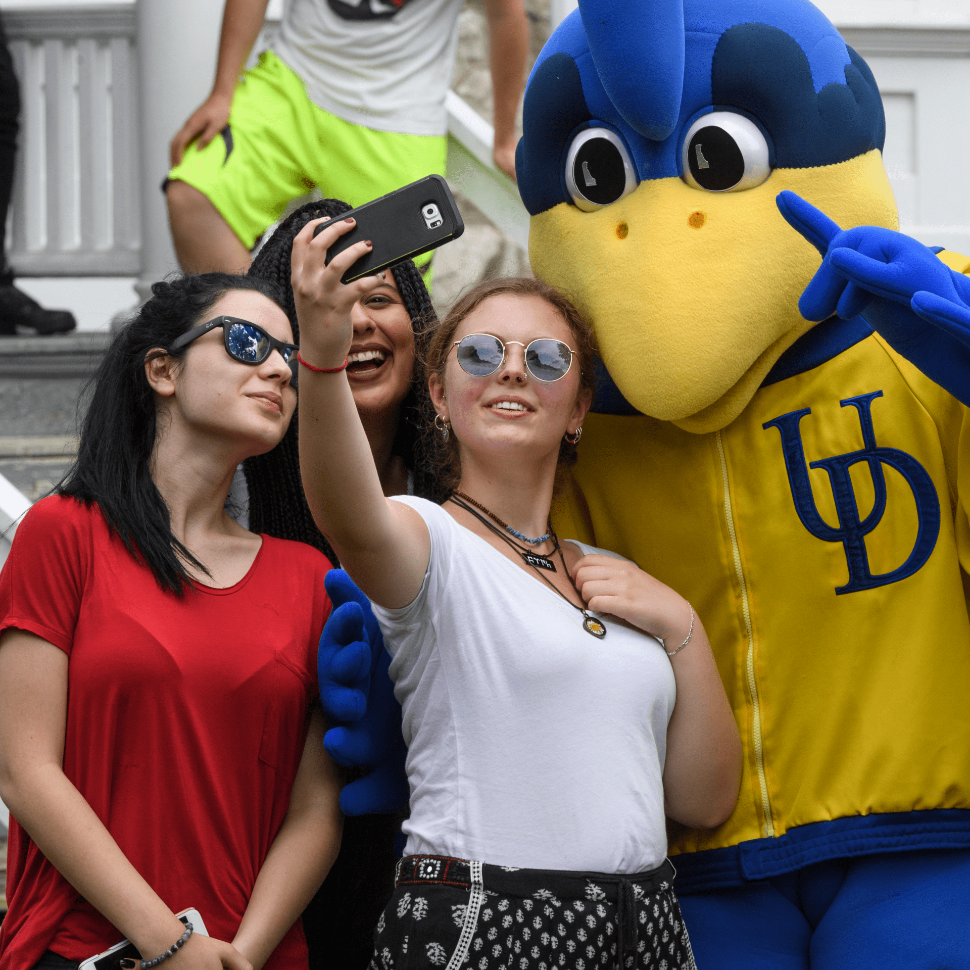 Students taking a selfie with YoUDee, the Blue Hen mascot