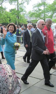 Sweden's Queen Silvia (with flowers) and King Carl XVI Gustaf (in sunglasses) exit the park.