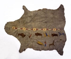 Three men on horses hunting three buffalo along with another man and two more horses all painted on a buffalo hide