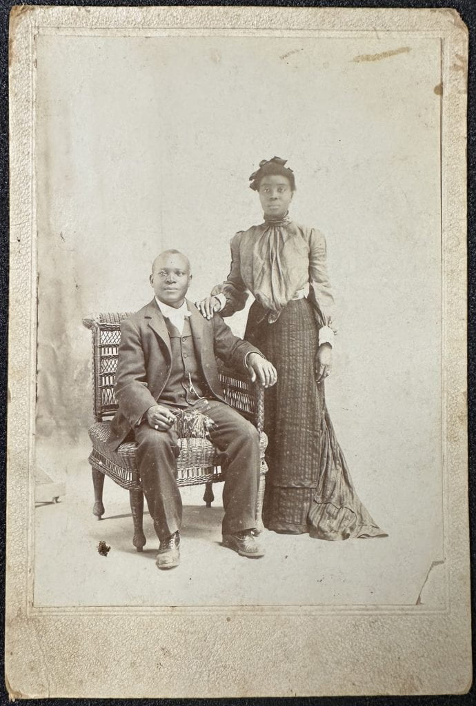 Portrait of a seated Black man and standing Black woman