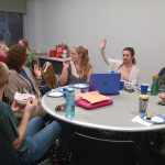 FFA members around a table with one raising her hand.