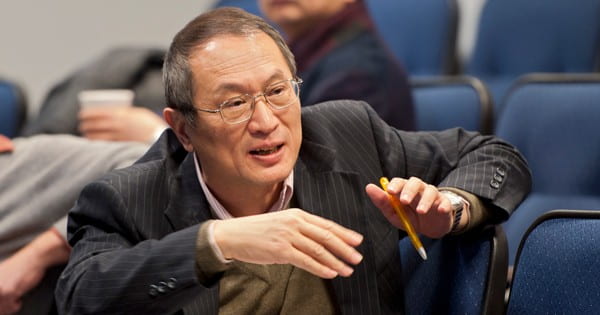 Dr. Yan seated in an auditorium, speaking with someone off camera.