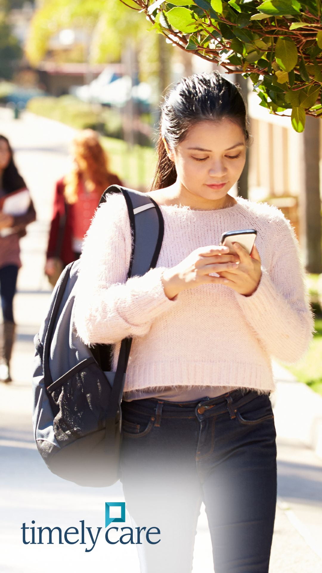 Female student walking and looking at phone