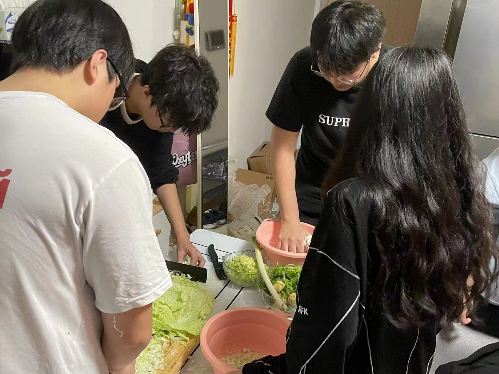 Four students chop and mix cabbage for dumpling filling at UD in China dumpling event