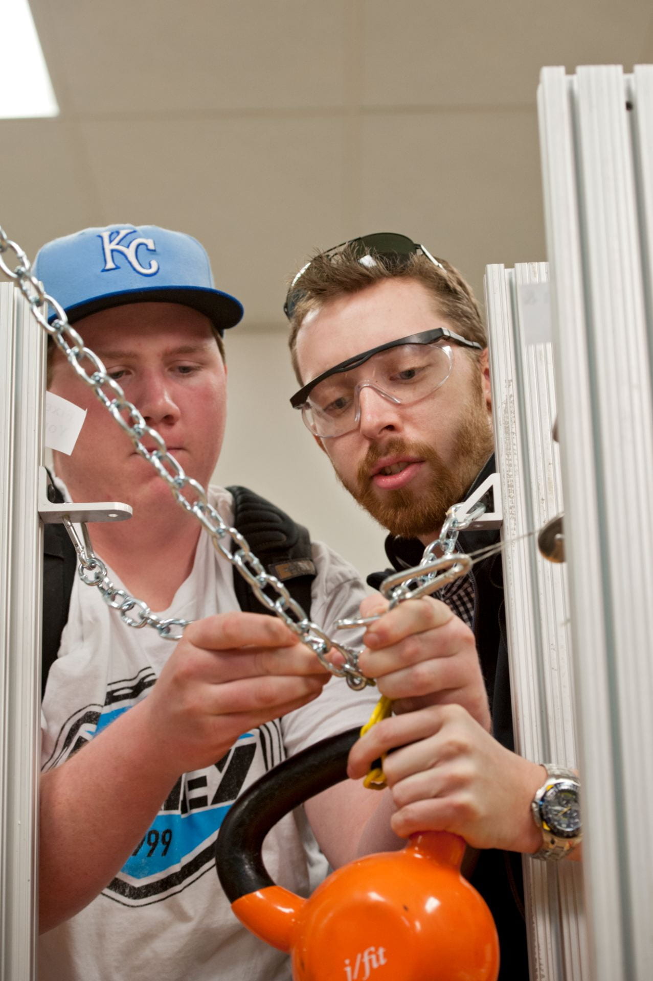 Two students apply their knowledge to a performance task in a mechanical engineering course involving chains and blocks.