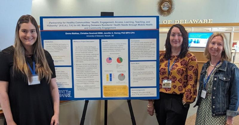 Partnership for Healthy Communities student and staff present a poster at the Provost's Symposium