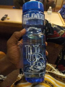 A Mandela Washington Fellow holds a UD water bottle