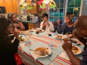UD Fellows enjoy dinner with a host family seated around a colorful table.