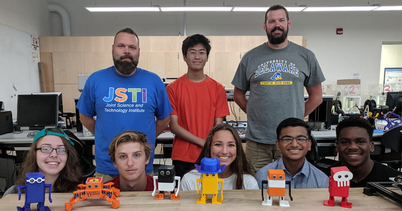 Students pose with robots they built