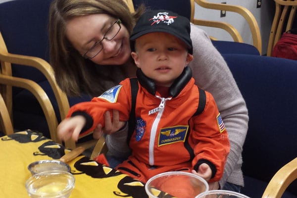 Toddler in orange astronaut costume
