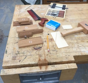 The tools for candle box assembly include: mahogany, chisels, saw, pencil, hammer, and the workbench.