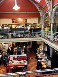 Interior view of Market Hall in Camden Market. Cakes, posters, and silver jewelry are on the first floor.