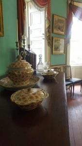 A covered soup tureen on a large serving dish is flanked by two covered vegetable dishes on a Charleston-made mahogany side table at the Nathaniel Russell House.