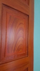 Close-up image of a paneled pine door that has been painted to look like mahogany.