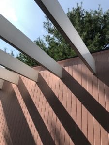 Outdoor photograph of pink wall and white beam ceiling of Gropius house balcony