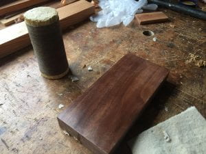 A polissoir and a rectangular piece of walnut.