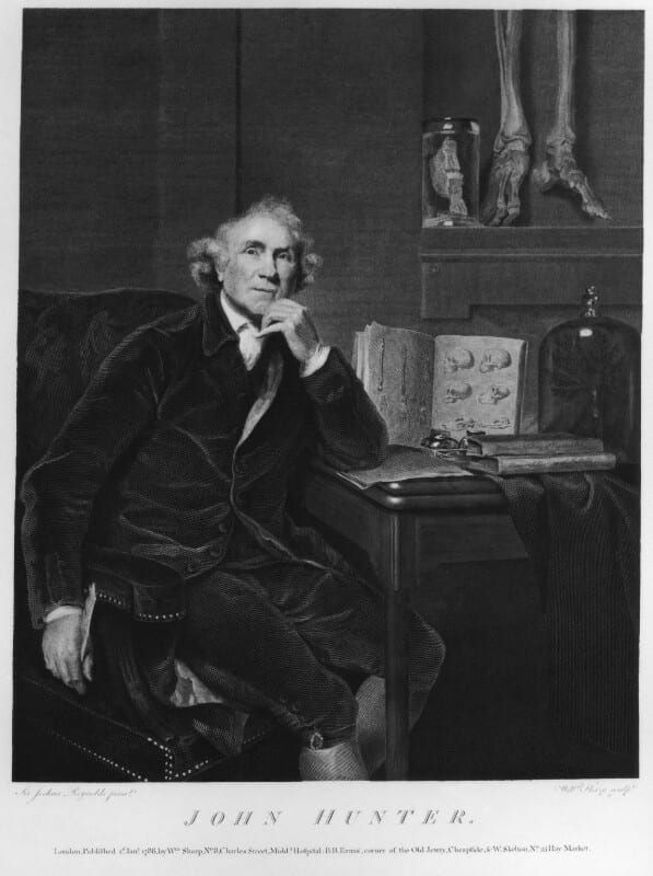Figure 3. Man sitting holding quill and looking out from desk with open books. 