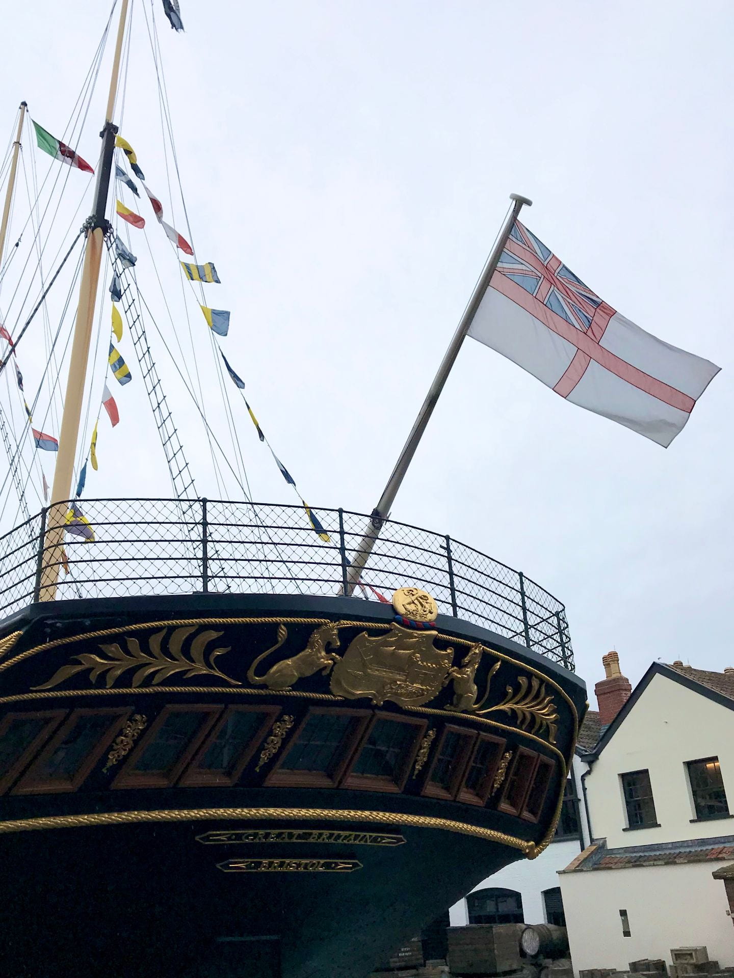 the stern of a large ship with flags