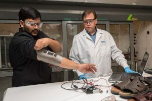 Sagar Doshi (black shirt, beard) and Erik Thostenson (light brown hair) from Mechanical Engineering have developed a fabric coating that contains thin, lightweight and flexible pressure sensors that can be embedded into shoes or other flexible garments.
