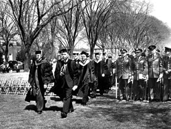 The procession for the University of Delaware commencement of 1965. To the right are pictured ROTC instructors and graduates receiving commissions as officers in the United States Army.