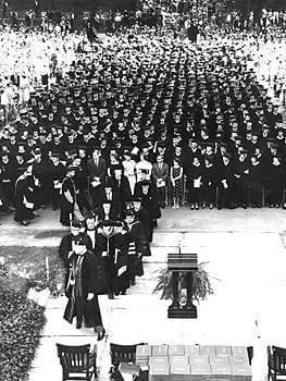 The graduating class of 1960 assembled on the North Mall in front of Hullihen Hall. G. Cuthbert Webber, Professor of Mathematics, leads the procession of administration and trustees to the podium.