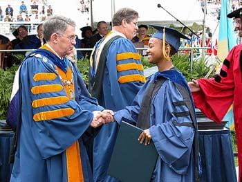 University of Delaware president David Roselle congratulates a graduate of the class of 2003 at commencement.