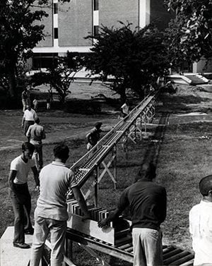 Photograph of a conveyer belt type construction built to facilitate the move from Memorial Hall to Morris Library. Photo by Richard Stewart. 1963.