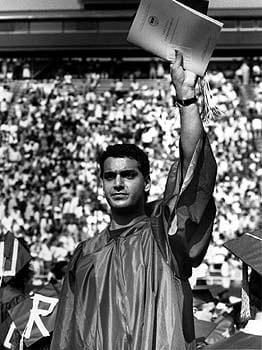 A University of Delaware graduate waves to the audience during commencement in 1990