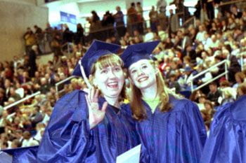 Two graduates of the class of 2001 show their happiness at commencement.