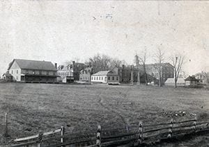 Photograph of the Old College area: View of Old College buildings from the North East, looking over the tract once used as an experimental farm and later landscaped as a portion of Frazer Field. Featured are Men's Gym (no longer in existence), Recitation Hall, Agricultural Experimental Station (now Recitation Hall Annex), Wood Shop (no longer in existence), Old College Hall, green house (no longer in existence), President Raub's House (no longer in existence). Circa 1895-1897.