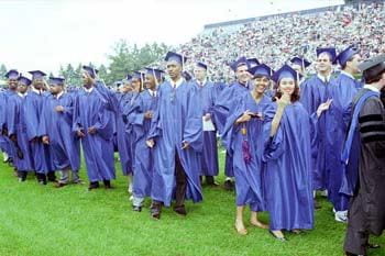 A crowd of happy graduates gathers on the field for the Spring 1993 commencement ceremonies.