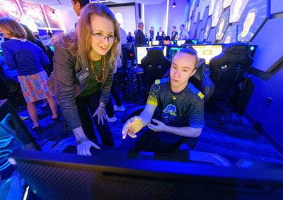 A student demonstrates a video game station to a female guest