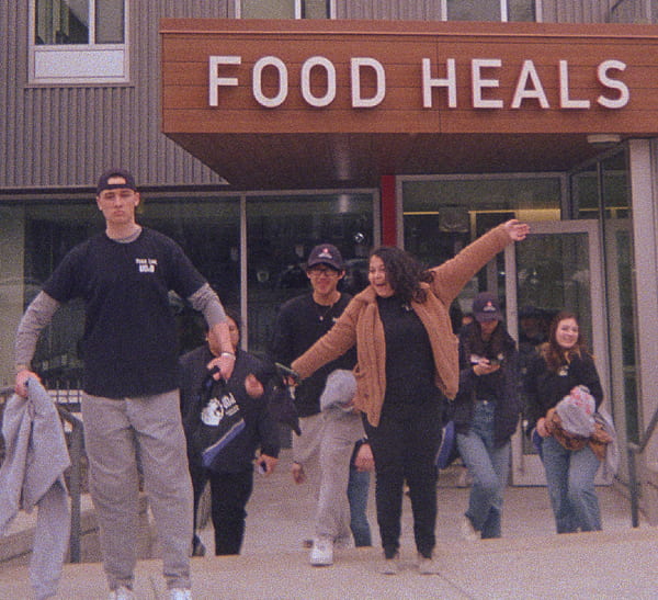several students strike silly poses as they exit a food bank where they've served
