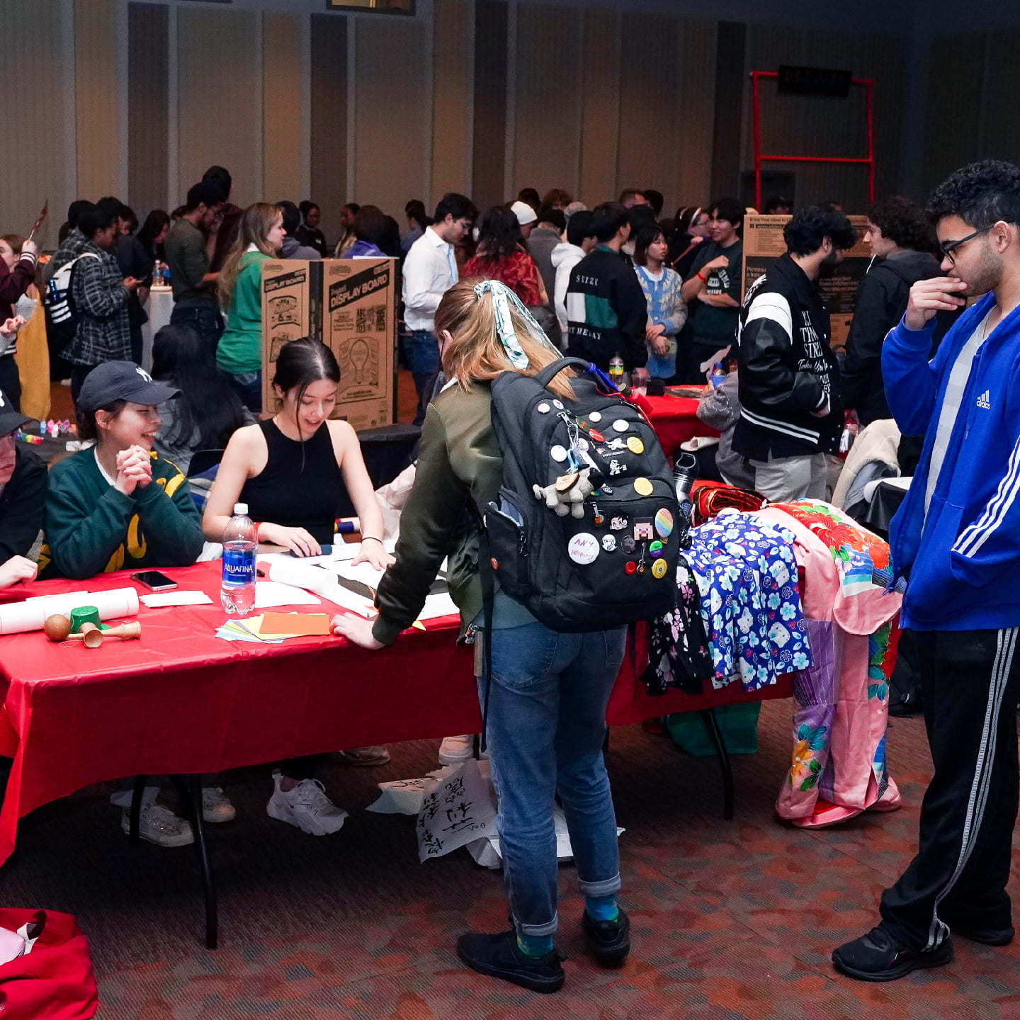 students attend tables with items on display